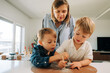 © Olga Moreira/Stocksy - Two young brother playing with fossil dig kit while mom watching