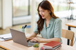 © David - Young business woman using calculator and laptop for doing math finance on an office desk, tax, report, accounting, statistics, and analytical research concept