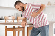 © Pixel-Shot - Young man having heart attack near table at home