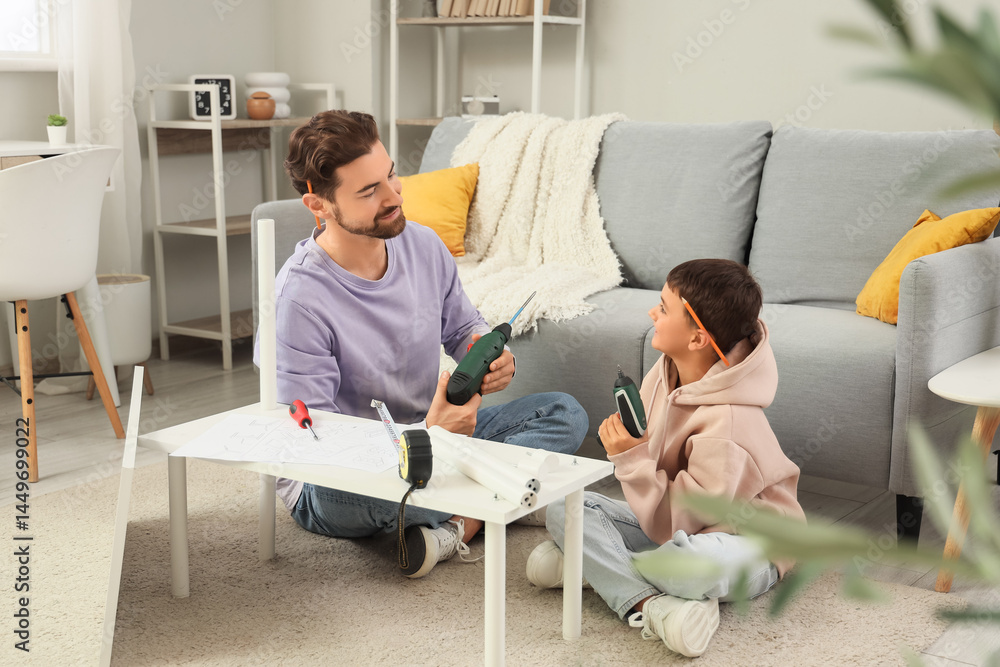 Father and his little son with instruments assembling shelf unit at ...