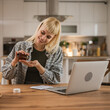 © Miljan Živković - Young woman hold and drink medical drug at kitchen at home