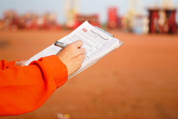 Wall Mural - a maintenance engineer is checking on checklist to verify the condition of forklift or heavy machine