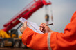 © Nattawit - An engineer or foreman is checking on safety checklist form of lifting crane at the drilling rig work site. Industrial safe working concent, close-up and selective focus.