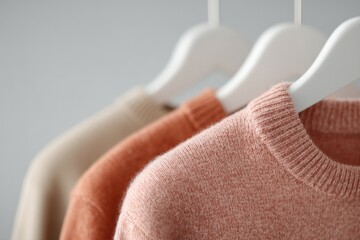 Wall Mural - minimalistic display of various clothing items on white hangers with plain background