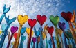 © Itsaree  - Colorful glass hearts held aloft against a blue sky.