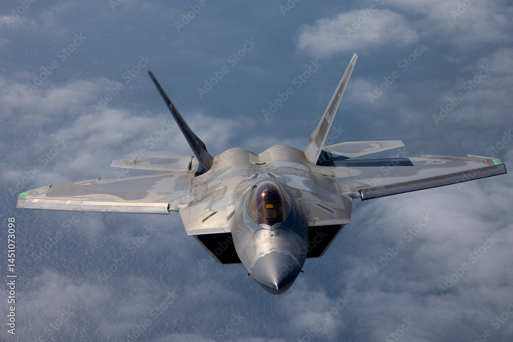 Frontal view of a a F-22 Raptor flying over the Pacific ocean and a ...