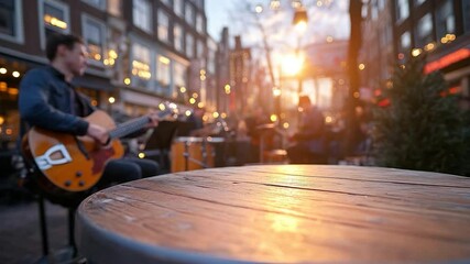 Poster - A close-up wooden table illuminated by golden sunlight forms the foreground while a musician plays guitar in a blurred outdoor cafe setting. Soft bokeh lights enhance the ambiance