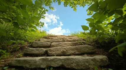 Leinwandbilder - Stone steps leading upwards framed by green foliage under a blue sky with clouds creating a natural archway, promoting peace and serenity