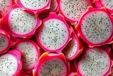 Overhead close up view of sliced vibrant dragon fruit with black seeds for freshness