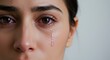 © ManuStockStudio - Close up of a woman's face with a tear rolling down her cheek showing emotion and sensitivity
