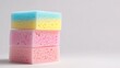 © aulaiphon - A stack of colorful cleaning sponges and scrubbers, isolated on a plain white background,