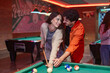 © luisrojasstock - Couple playing billiards and having fun together in pub