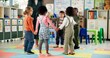 © peopleimages.com - Group, children and holding hands with teacher in circle for playing, game and fun activity at recess. Montessori, kids and learning break for classroom community, motor skills and growth development
