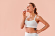 © HBS - A beautiful athletic girl with a toned body in a white bra and leggings wants to eat a delicious pastry.