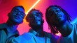 © artbot - Three young men in stylish clothing posing in vibrant neon light