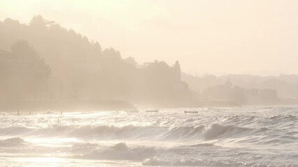 Wall Mural - golden sunlight bathing rocky portuguese coastline, highlighting breaking waves with warm glow and c