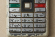 © Shamil - close-up of worn out physical keypad of old obsolete mobile phone, mechanical buttons arranged in grid of T9 format or layout with navigation keys and call buttons