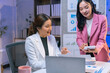 ©  NCST Studio - Two Asian businesswomen working late together using laptop and calculator in office, discussing about business plan