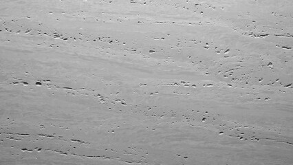 Fototapete - A grey wall with a lot of cracks and holes. The wall is made of concrete and has a rough texture.