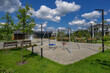 © Alhim - Playful afternoon in a well-designed park featuring swings and lush greenery under a bright blue sky