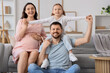 © Pixel-Shot - Happy little girl with her father and pregnant mother sitting at home