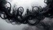 © zainal - Abstract black smoke swirling elegantly against a light gray background, creating a calming effect.