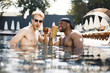 © prostooleh - Two male friends relaxing with a cocktails in a swimming pool