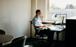 © Flamingo Images - Modern Office Workspace, With Professional moden man in a blue shirt, Working at Desk by the Window.