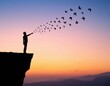 © Imran - Silhouette man releasing birds at sunset on cliff edge concept of freedom and letting go illustration mental health