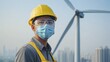 © Dari - Asian wind turbine technician wears mask and safety gear against a skyline and a turbine in the background