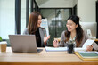 © jojo - Two colleagues working together intently in an office.