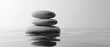 © Qbertstudio - Stacked stones balance precariously above reflective water, promoting calmness.