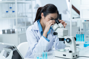 Wall Mural - asian researcher using a microscope in the clinical lab.female researcher working in the clinical la
