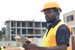 © Sean Hoong - construction supervisor in helmet with clipboard, Black professional at project site