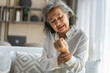 © Art_Photo - Elderly asian woman holding wrist pain, arthritis, health issue, senior female suffering from joint pain at home, expressing discomfort, aging health problem, chronic condition indoor living room