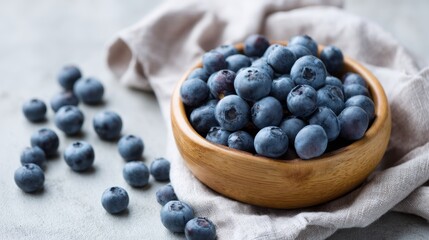 Aufkleber - A rustic wooden bowl filled with plump blueberries rests on a soft linen cloth, illuminated by natural light that casts delicate shadows, enhancing the textures