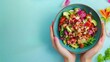 © Friendly Studio - Womans hands holding colorful salad bowl over blank surface, healthy lifestyle concept, ready for text or inscriptions