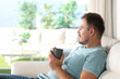 © Antonioguillem - Man relaxing drinking coffee in a house interior