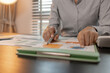 © kamiphotos - businessman is checking financial documents to match the information summarized by the accounting department, accountant, marketing department, working in the office with paperwork