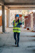 © Ljustina - Female engineer walking and talking on phone at construction site
