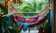 © k_viktar - Cozy balcony hammock with colorful pillows and tropical plants in serene setting.