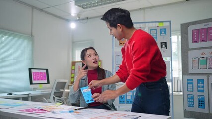Wall Mural - asian ux designers collaborating in modern office, arranging colorful paper prototypes while refinin