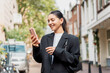 © Andrei - Stylish young woman exploring a new neighborhood, using her phone for local guides, mobile banking, and mindful check-ins