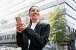 © Andrei - Stylish successful woman entrepreneur in her mid-20s in a suit texting in the city, effortlessly balancing finance tools and mindful travel on a busy workday
