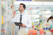 © ultramansk - man pharmacist checks and arranges medicines on pharmacy shelves, emphasizing precision and responsibility in healthcare services. The scene highlights the daily operations in a modern pharmacy.