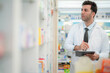 © ultramansk - man pharmacist checks and arranges medicines on pharmacy shelves, emphasizing precision and responsibility in healthcare services. The scene highlights the daily operations in a modern pharmacy.