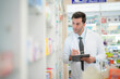 © ultramansk - man pharmacist checks and arranges medicines on pharmacy shelves, emphasizing precision and responsibility in healthcare services. The scene highlights the daily operations in a modern pharmacy.