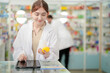© ultramansk - A woman pharmacist inspects a medication bottle, ensuring accuracy in prescription filling. pharmacists in patient safety and careful medication handling. daily operations in a modern pharmacy.