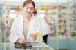 © ultramansk - A woman pharmacist inspects a medication bottle, ensuring accuracy in prescription filling. pharmacists in patient safety and careful medication handling. daily operations in a modern pharmacy.