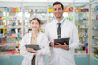 © ultramansk - team man and woman pharmacist inspects a medication bottle, ensuring accuracy in prescription filling. pharmacists in patient safety and careful medication handling. operations in retail pharmacy.